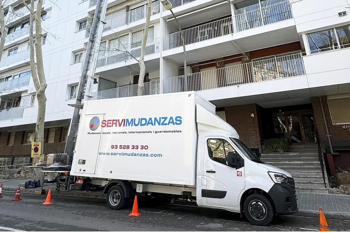 Camión de Servimudanzas con elevador trabajando en un edificio de apartamentos de La Cerdanya